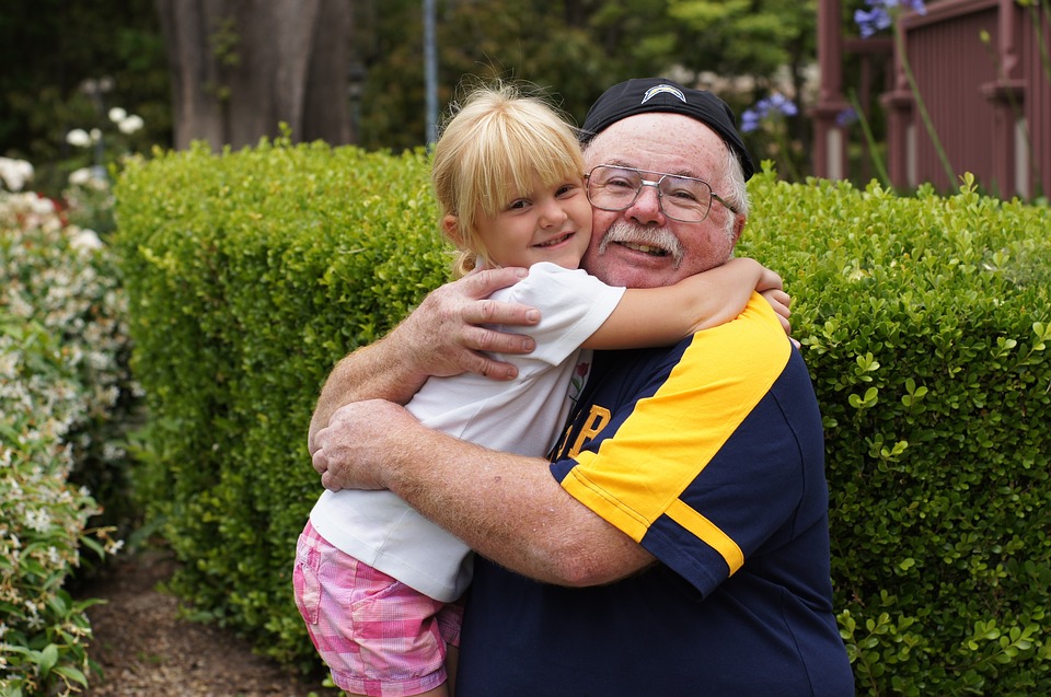 older man hugging child