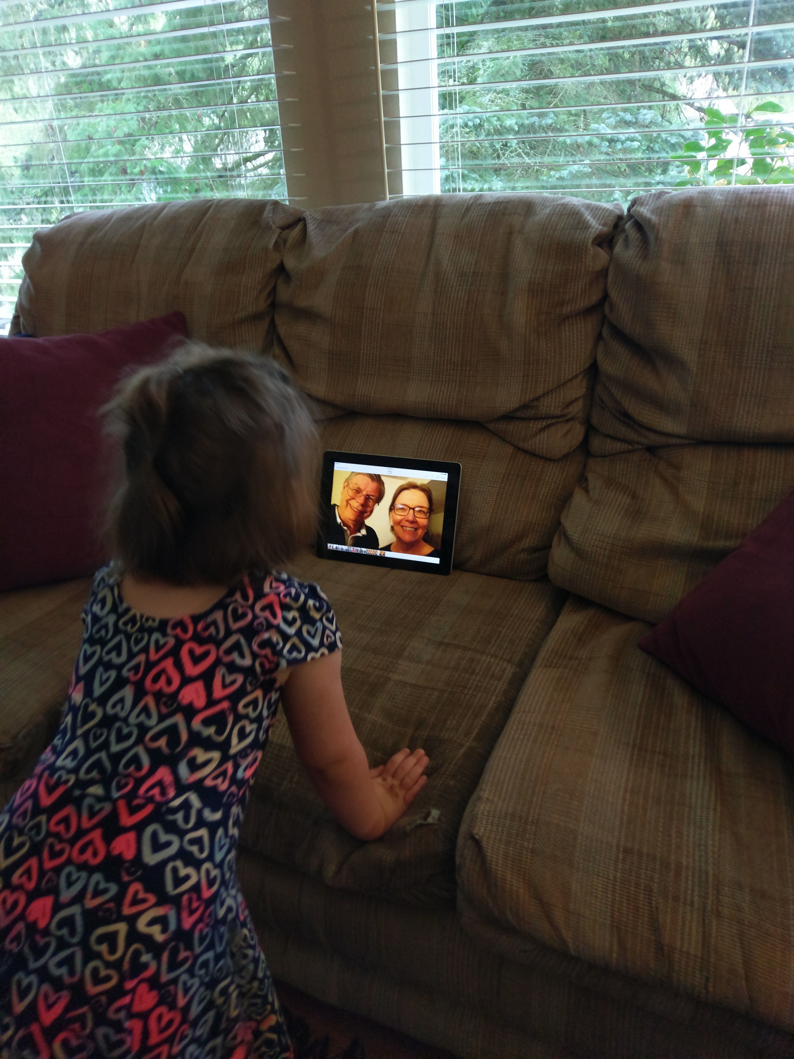 child watching grandparents on tablet